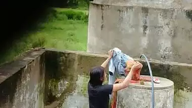 Indian village girl bathing near water tank outdoor